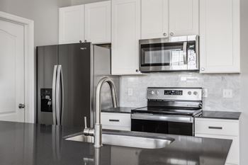 A modern kitchen with stainless steel appliances and white cabinets